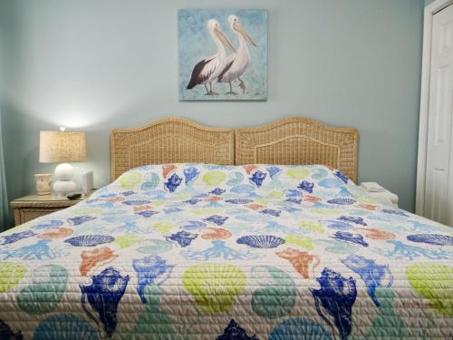 - un lit avec une couette colorée et 2 oiseaux dans l'établissement 26i WWV Myrtle Beach Intracoastal Waterway Gem, à Myrtle Beach