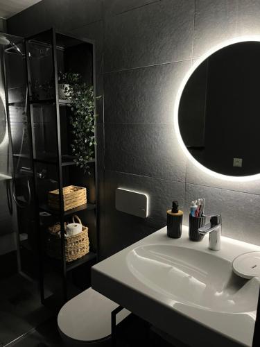a bathroom with a white sink and a mirror at Albatross Beach Apartment - SPA, Sea and Forest in Ķesterciems
