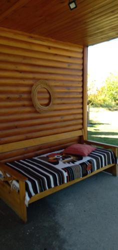 a bed in a wooden room with a wall at Cabañas RoFran in La Consulta