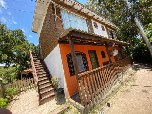 Casa de color naranja y blanco con porche y escaleras en Pousada Beija Flor en Ilha do Mel