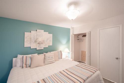 1 dormitorio con cama y pared azul en 201D Jenns Bay Retreat, en Myrtle Beach