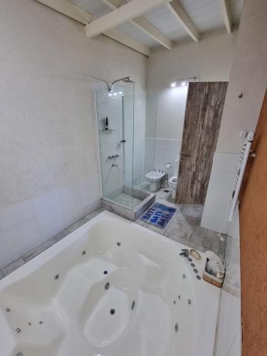 y baño con ducha y bañera blanca. en Casa Barrio Nayades en Pinamar