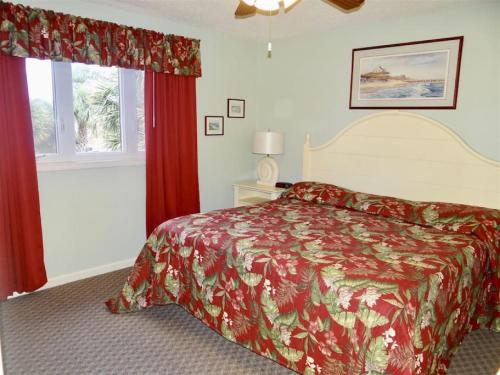 a bedroom with a bed with a red bedspread at Deerfield Plantation 217A2 in Myrtle Beach