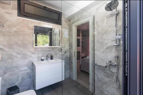 a bathroom with a shower and a toilet and a sink at Avithos Blue Villas in Svoronata