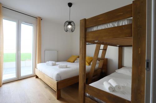 Ce dortoir comprend 2 lits superposés et une fenêtre. dans l'établissement Reflet du Parmelan Annecy, à Annecy