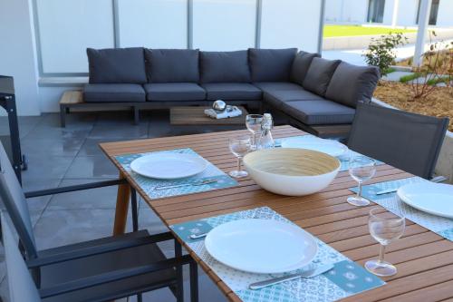 une table en bois avec des assiettes et des verres à vin dessus dans l'établissement Reflet du Parmelan Annecy, à Annecy