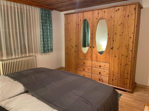a bedroom with a mirror and a wooden dresser at Haus Kreuzboden in Hundsdorf