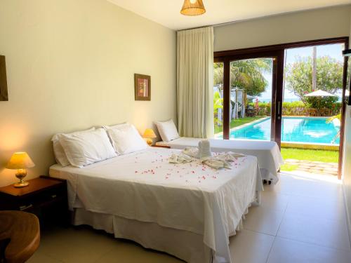 a bedroom with a bed and a pool at Pousada San Giovanni in Japaratinga