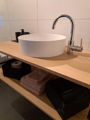 a white sink on a wooden counter with towels at Hessener Esch in Dalfsen