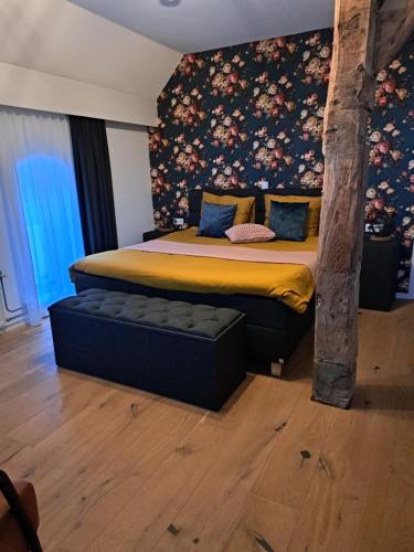a bedroom with a bed with a floral wall at Hessener Esch in Dalfsen