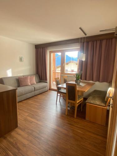 uma sala de estar com um sofá, uma mesa e cadeiras em Apart Berghof em Fiss
