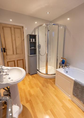 a bathroom with a shower and two sinks and a tub at Skipton at Six in Skipton