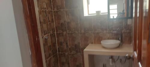 a bathroom with a toilet and a sink and a window at Hospedaje Venka Urubamba in Urubamba