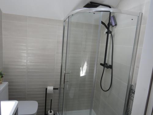 a shower with a glass door in a bathroom at The Tack Room at Eastmoor Farm in Bridlington