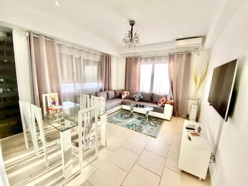 een woonkamer met een bank en een tafel bij Tulipe appartement in Oran