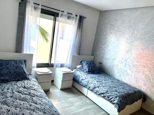 1 dormitorio con 2 camas y ventana en Appartement très Haut standing vue sur mer à Mohammedia, en Mohammedia