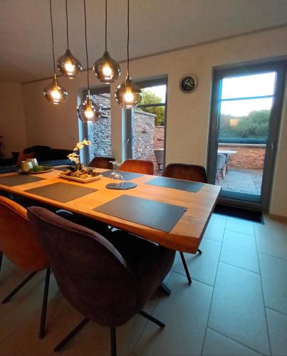 a dining room with a wooden table and chairs at Attraktive Wohnung-Elztalidyll-zwischen Mosel,Nürburgring und Burg Eltz in Kollig