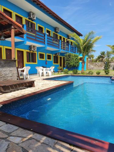 a house with a swimming pool in front of it at Pousada Retiro das Caravelas in Cananéia