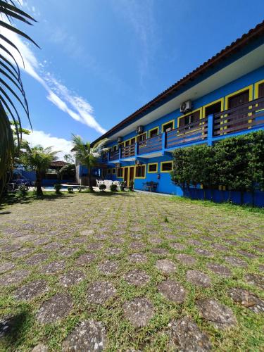 a building with a yard in front of it at Pousada Retiro das Caravelas in Cananéia
