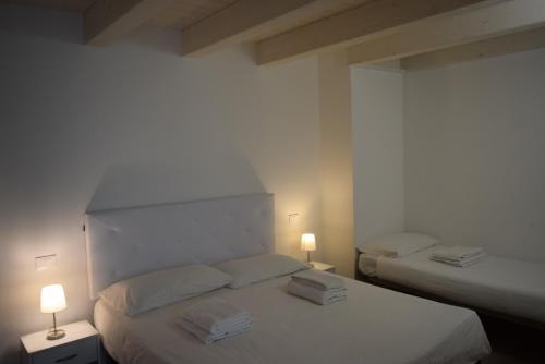 two beds in a room with two lamps on them at Villa AMARE in Caorle