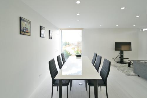 a dining room with a white table and chairs at NISEKO EPIC HOUSE in Niseko