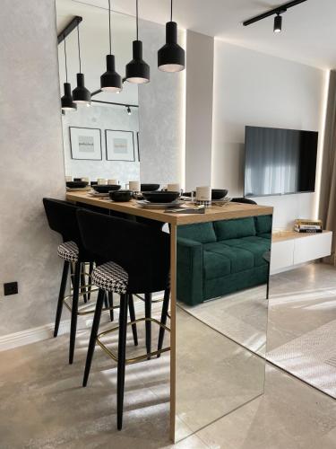 a kitchen with a table with chairs and a green couch at President Lux Apartment in Pale
