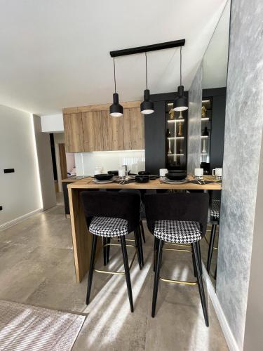 a kitchen with a island with black chairs at President Lux Apartment in Pale