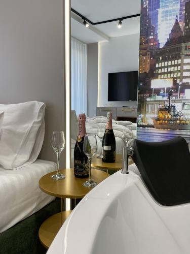 a hotel room with two bottles of wine on a table at President Lux Apartment in Pale
