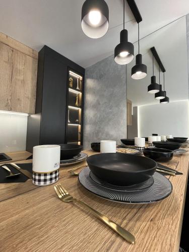 a table with a black bowl and plates on it at President Lux Apartment in Pale