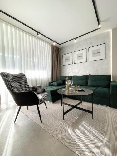 a living room with a green couch and a table at President Lux Apartment in Pale