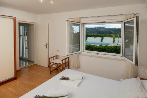 a bedroom with a bed and a large window at Villa Lilin San in Donji Humac