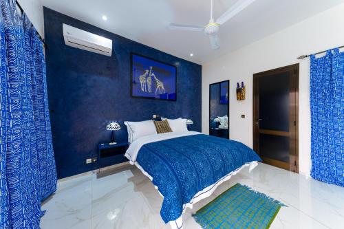 a blue bedroom with a bed and a blue wall at ChezBabo Wellness Hotel in Ngaparou