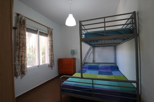 Łóżko piętrowe w pokoju z oknem w obiekcie CHALET CON PISCINA A 100m DE LA PLAYA LA MANGA w mieście La Manga del Mar Menor