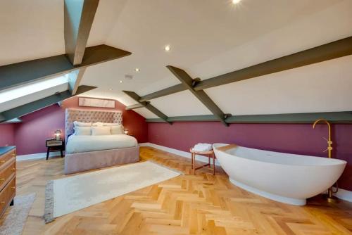 ein Schlafzimmer mit großem Bett und Badewanne in der Unterkunft Newly renovated 4 Bedroom Cottage with Wood Burner in Aysgarth