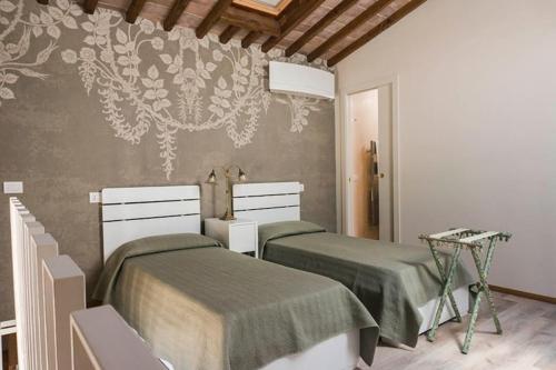 1 dormitorio con 2 camas y un mural en la pared en FAETOLE typical Tuscan country house near FLORENCE, en Capannuccia