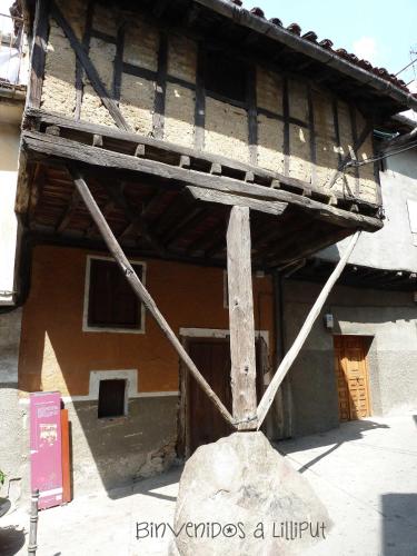 an old building with a wooden balcony on top of it at Hostal Yuste in Garganta la Olla