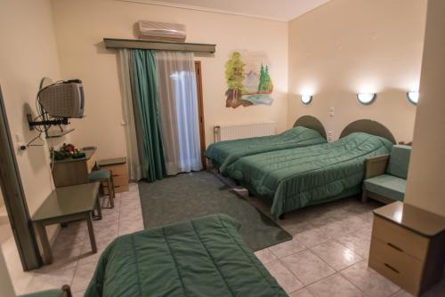 a hotel room with two beds and a television at Artemis in Karpenisi