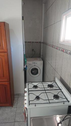 une cuisine avec une cuisinière et une machine à laver dans l'établissement El Depto de la Abuela, à Puerto Iguazú