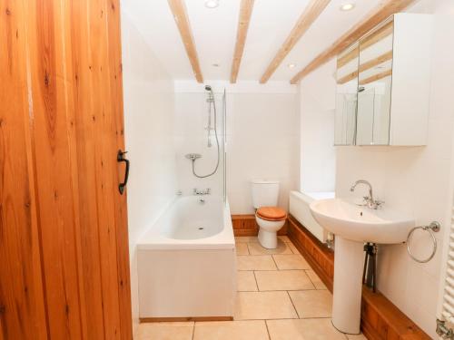 a bathroom with a tub and a toilet and a sink at Gladstone in Pwllheli
