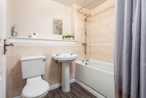 a bathroom with a toilet and a sink and a tub at Isla Retreat - Donnini Apartments in Ayr