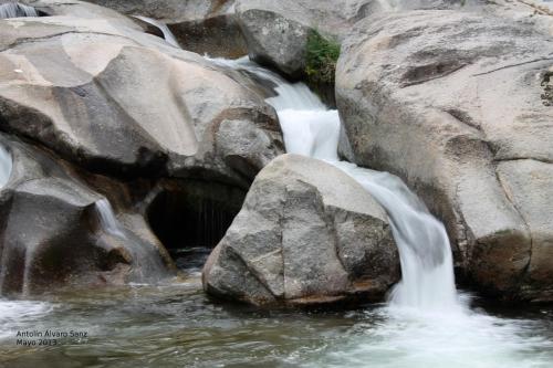 a stream of water flowing over rocks in a waterfall at Hostal Yuste in Garganta la Olla