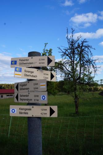 a street sign with arrows pointing in different directions at Kleine Ferienwohnung auf dem Land, Haus Hans Stepha in Gößweinstein