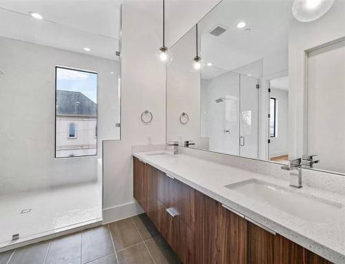 a bathroom with two sinks and a large mirror at 4 Story Home Mins To Downtown Houston with City Views in Houston