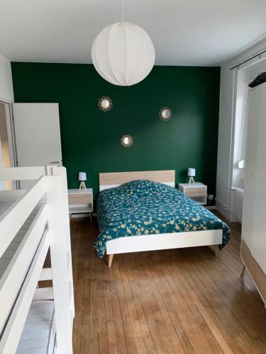 - une chambre avec un mur vert et un lit dans l'établissement Appartement centre-ville rénové 6/8 personnes, à Gérardmer