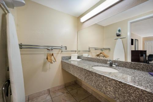 a bathroom with a sink and a mirror at Knights Inn College Station in College Station