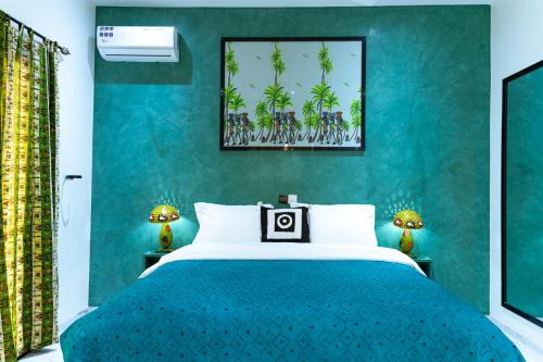 a bedroom with a large bed with a blue wall at ChezBabo Wellness Hotel in Ngaparou
