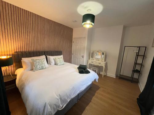 a bedroom with a white bed and a television at Modern & retro two bedroom apartment in Barnsley in Barnsley