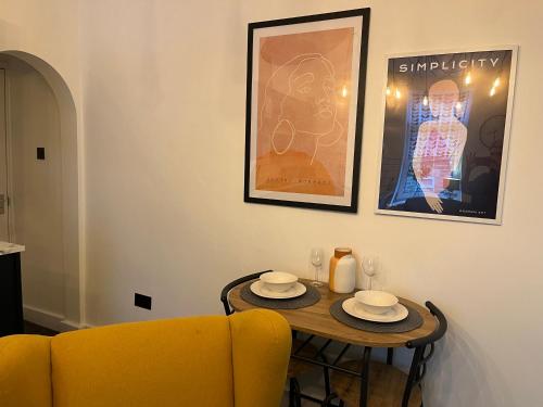 a living room with a table and a yellow couch at Modern & retro two bedroom apartment in Barnsley in Barnsley