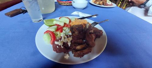 un plato blanco con comida en una mesa azul en Cabaña Velo de Novia, en Socoltenango