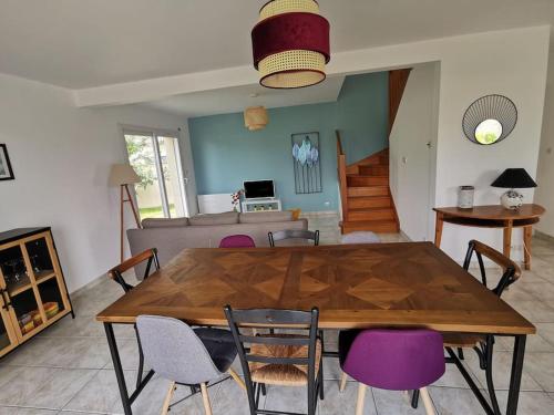 uma sala de jantar com uma mesa de madeira e cadeiras em Maison de vacances proche des plages et du GR34 em Sibiril